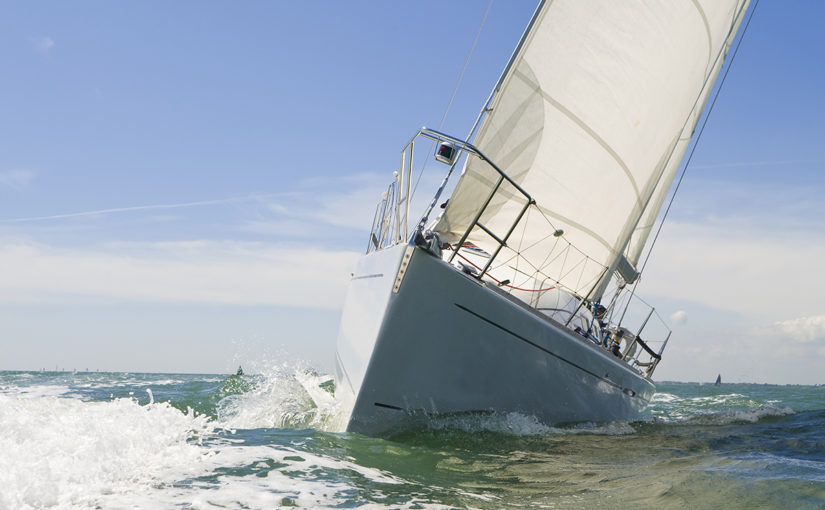 A beautiful white yachts racing close to the camera on a bright sunny day